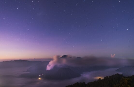 Sunrise and stars, smoking volcano, Gunung Bromo, Mount Batok, Mount Kursi, Mount Semeru, Bromo Tengger Semeru National Park, Java, Indonesia