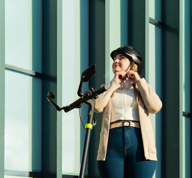 Woman adjusting helmet for eco friendly urban commuting