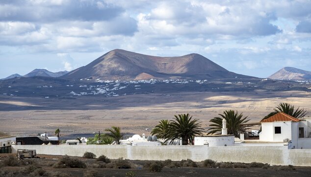 Volcanic landscape with volcanic cone, white houses in the village of Teguise, Lanzarote, Canary Islands, Spain