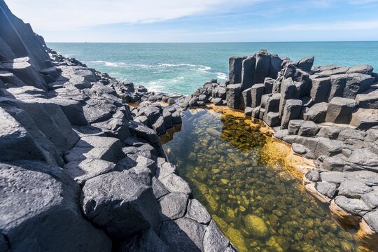 Water gathering between rocks, Roman Bath, Hexagonal basalt column by the Sea, Blackhead, Dunedin, Otago, South Island, New Zealand