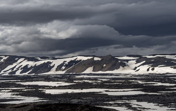Snow-covered volcanic landscape with volcanic sand and petrified lava, crater of Askja volcano, Icelandic highlands, Iceland