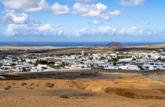 View of town, white houses of Teguise with church tower in dry volcanic landscape, Lanzarote, Canary Islands, Spain
