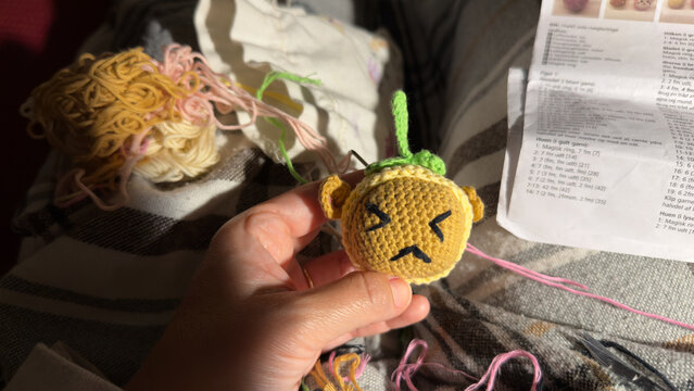 Hand holding small handmade crochet toy