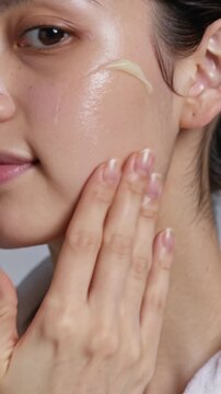 Young Woman Applying Moisturizing Face Cream for Skincare Routine (Vertical Video)