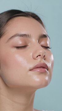 Close up of young woman with glowing skin and closed eyes (Vertical Video)