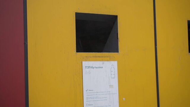 Person standing at recycling station, waste disposal, environmental awareness, public facility, sustainability initiative, waste management education, recycling awareness campaign, urban setting