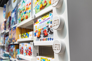 Naklejka premium 19 October 2025, Belgrade, Serbia: LEGO toy store aisle with shelves displaying various colorful box sets and large branded wall elements