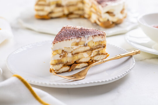 Delicious homemade tiramisu dessert with banana slices and cocoa powder