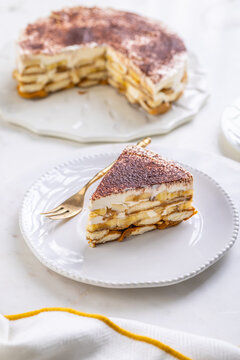Delicious homemade tiramisu dessert with banana slices and cocoa powder