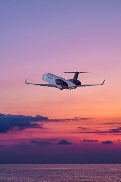 Executive aircraft take off over the ocean against the backdrop of scenic sunset sky