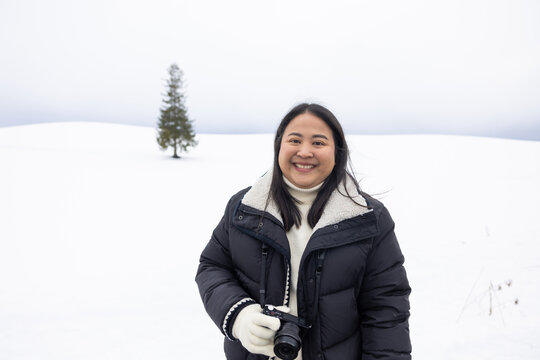 Portrait Beautiful asian fat woman smile happy travel and enjoy with snow winter season. Wearing thick coat, Snowy landscape surrounds, Joyful winter moment, perfect for family scenes. Vacation