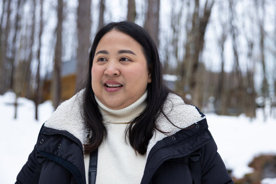 Portrait Beautiful asian fat woman smile happy travel and enjoy with snow winter season. Wearing thick coat, Snowy landscape surrounds, Joyful winter moment, perfect for family scenes. Vacation