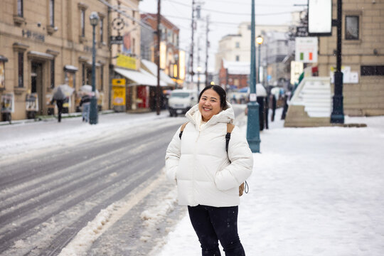 Portrait Beautiful asian fat woman smile happy travel and Standing on Sidewalk with Mountain and Cityscape Background. Enjoying a Sunny Winter Day in a Picturesque Town. posture suggests curiosity