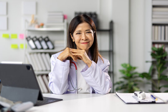 Senior female doctor sitting confidently at her desk in her office. Online health consultation services.