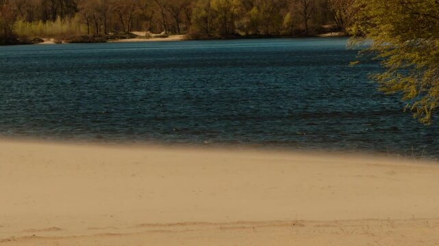Wind Blowing Sand On Empty River Beach During. Sandy Coastline. Landscape Scene Of Deserted Shoreline