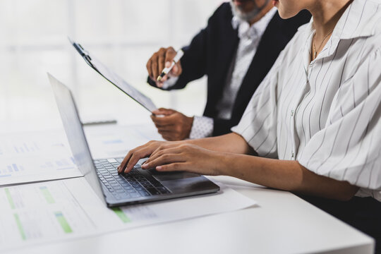 Business people are collaborating on financial analysis, reviewing charts and graphs on a digital tablet and clipboard, business growth and market trends in an office meeting.