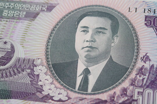 Close-up macro view of a 5000 North Korean Won banknote featuring the portrait of Kim Il-sung. DPRK paper currency details. 