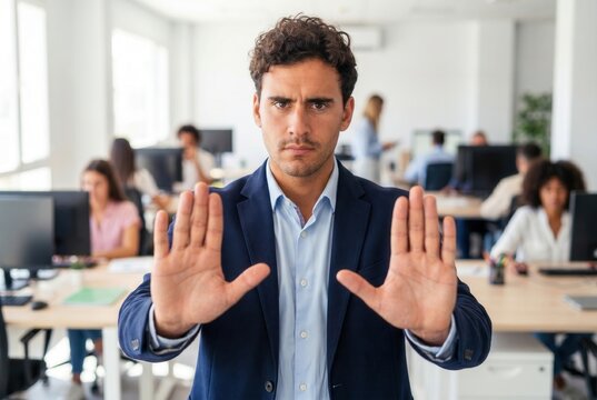 Serious businessman making a stop gesture with open hands in a modern office environment