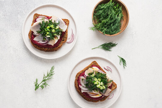 Open sandwich with herring beetroot mousse egg dill and green onion, traditional Scandinavian cuisine appetizer concept top view