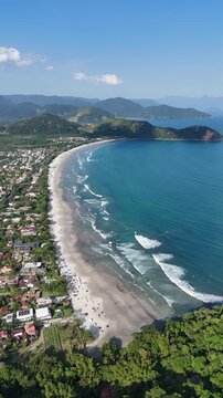 Vista a&eacute;rea da Praia da Baleia com mar azul, faixa de areia extensa e vegeta&ccedil;&atilde;o preservada, destacando turismo, natureza e paisagem costeira no litoral brasileiro