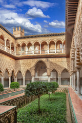 Naklejka premium Main courtyard Patio de las Doncellas in Alcazar of Seville Spain. Mudejar architecture with arches and stone columns