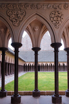 Mont Saint-Michel, France: Close up of intricate floral stone carvings and pointed arches in the Benedictine abbey cloister garden. Medieval art.