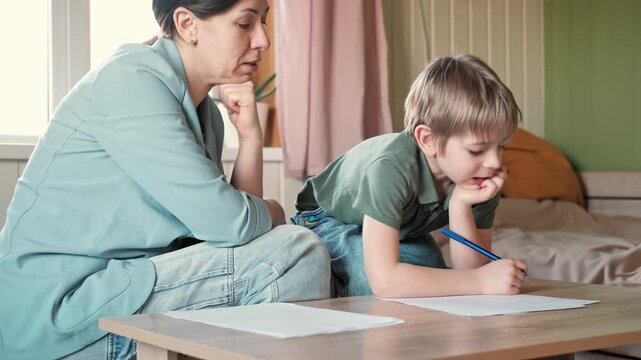 Mom education son writing. Kids learn and study in home school. Mommy female helping teaching little boy support studying, learning homework. Child care teach study. Knowledge day. Children schooling.