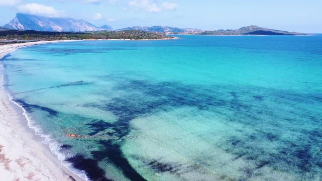 Aerial view of Lu Impostu beach with turquoise sea, white sand and shallow crystal waters in Sardinia, showing smooth color gradients and Mediterranean coastal scenery.