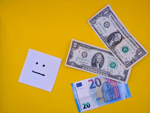 Cash dollars and euros on a yellow background
