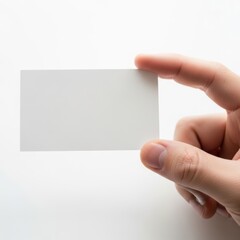 Obraz premium A hand holding a blank white rectangular card against a light background