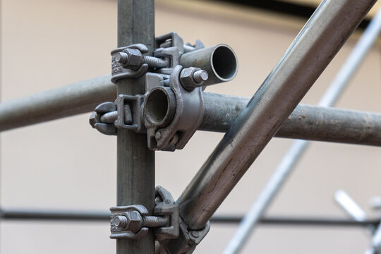 Heavy duty metal scaffolding clamps on a construction site symbolizing connections and structure and providing ample copy space.