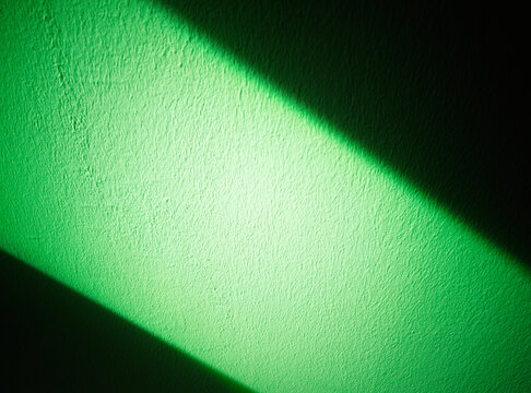 Ray of light falling on green wall background
