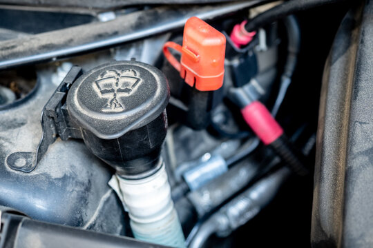 Close-up of a car windshield washer fluid reservoir cap inside the engine bay - concept of vehicle maintenance, fluid check and automotive components