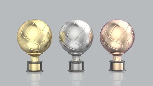 Gold, silver, and bronze volleyball or football trophies on shiny grey background