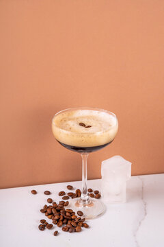 Trendy viral italian iced coffee drink caffee shakerato, cold summer whipped coffee with simple Liqueur and ice in martini cocktail glasses