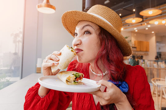 Woman making a suspicious, disgusted face while smelling a chicken wrap or burrito with sauce, reacting to an unpleasant odor and questioning food freshness