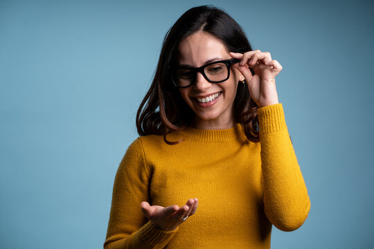 Happy female exploring AR AI glasses and modern technology advantages on blue