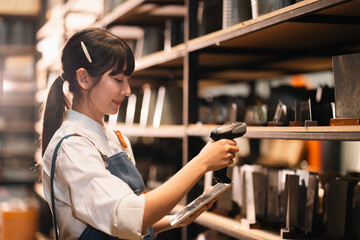 Female retail worker scanning product in store aisle with handheld barcode reader © chokniti