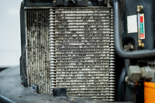 Industrial machine heat exchanger with exposed cooling fins, side radiator core and fluid gauge for maintenance and rental fleet inspection work site