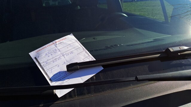 Close-up of a traffic ticket written on the windshield, written in Italian