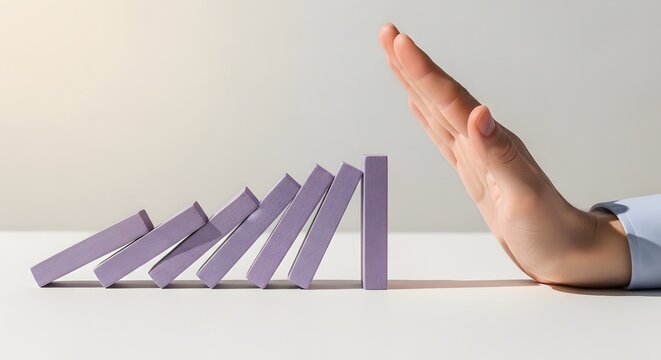 Hand Stops Falling Dominoes for Business Growth Strategy
