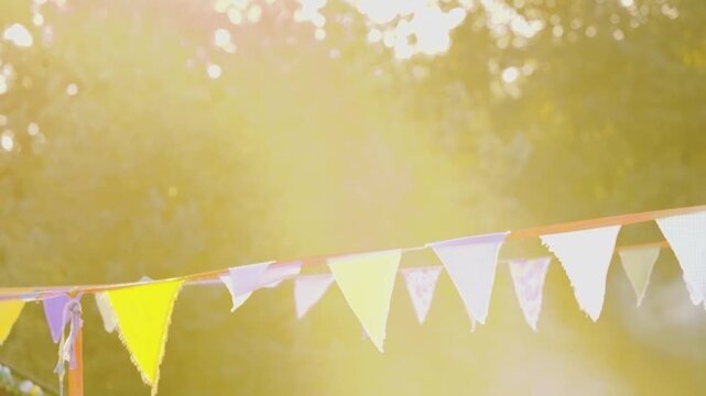 Girlanden auf Festival im warmen Sonnenlicht mit Rauch und B&auml;umen im Hintergrund