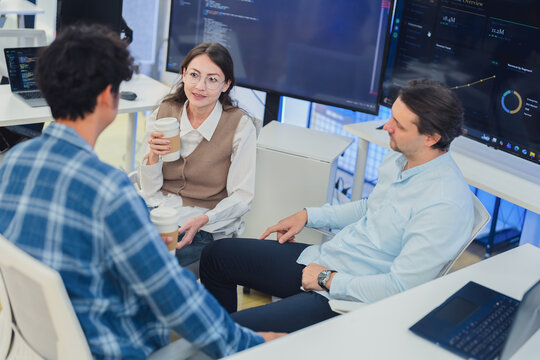 Diverse Tech Team Collaborating and Discussing Project Strategy During Coffee Break in Modern AI Office