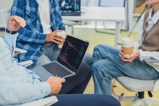 Tech Team Collaborating on Software Development with Laptop and AI Data Dashboard in Modern Startup Office