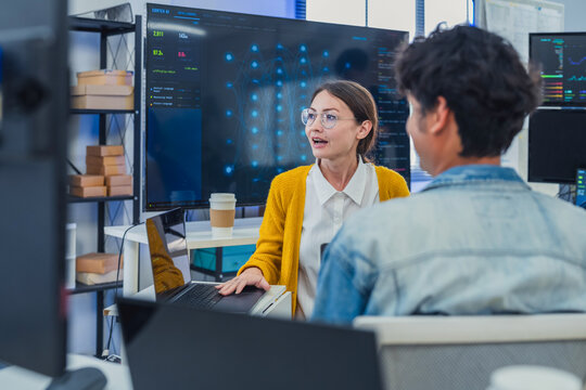 Professional Female Specialist Explaining Advanced AI Neural Network Data to Tech Team in Modern Office