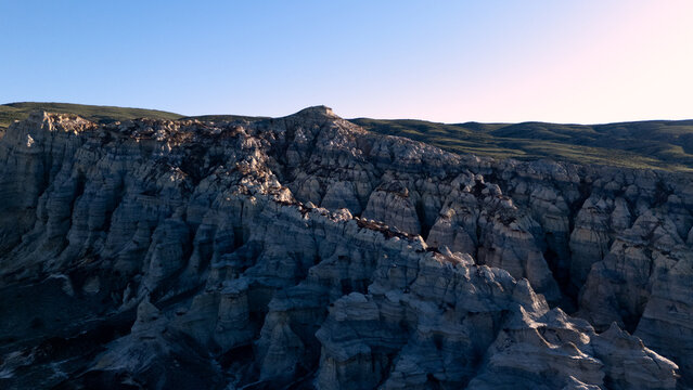 Panoramic aerial photography of the Kokkala canyon in Mangystau, Kazakhstan, during the golden hour. The photo captures unique eroded chalk and white clay cliffs resembling an alien planet surface. 