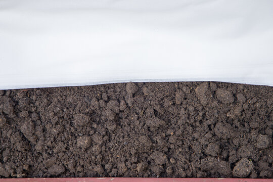 White geotextile on the ground. Soil preparation for planting.