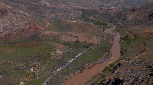 Aerial view of train winding through rugged, earthy valley (Dogu Ekspresi/Turkey)