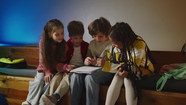 Four diligent school friends discussing task while working on project together