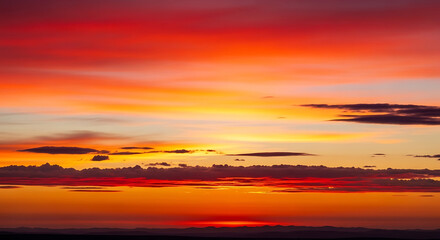 Fototapeta premium vibrant orange and red sunset with clouds
